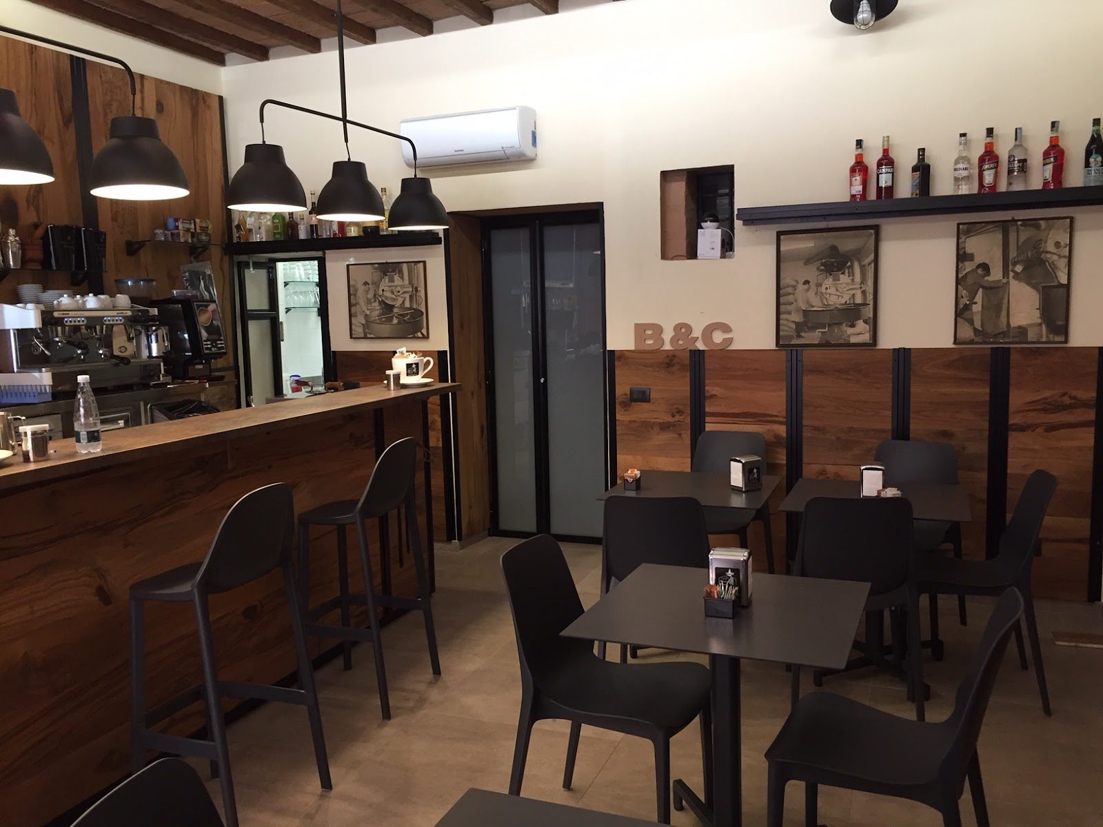 Il bancone in legno e l'insegna dell'Osteria Antica Ferramenta